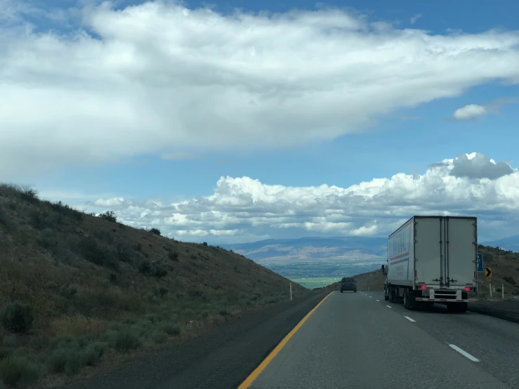 the back end of a semi truck driving on the road