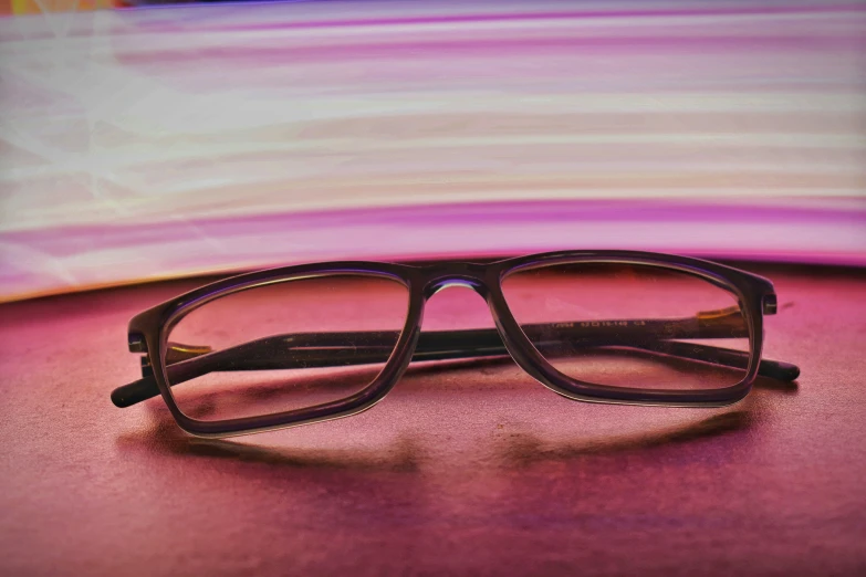 glasses with pink and purple art background sitting on a table