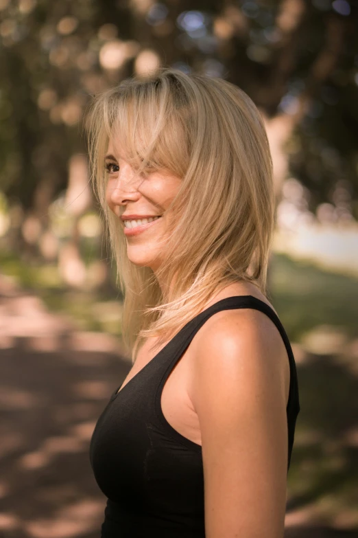 a young blonde woman standing with her head turned to the side