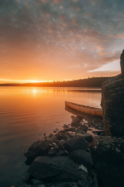 a sunset over water with a shore line in the foreground