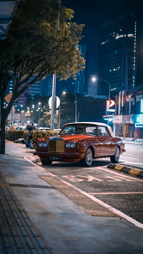 an old fashion red station wagon car parked on the side of a road