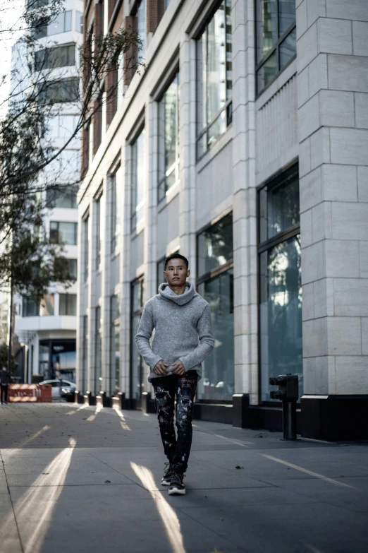 a woman is walking in the sun in front of a building