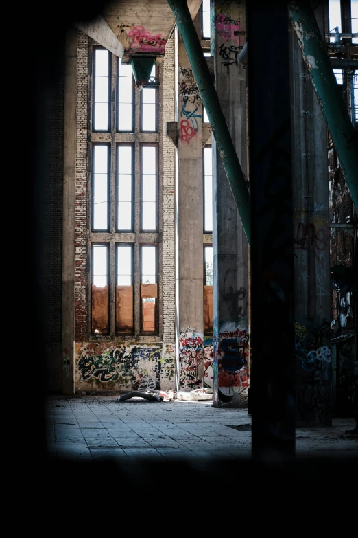 an abandoned building with graffiti and open windows