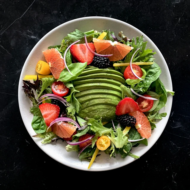 a large white plate with fruit and vegetable