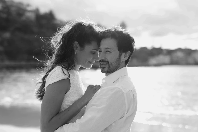 a man and a woman standing together on the beach