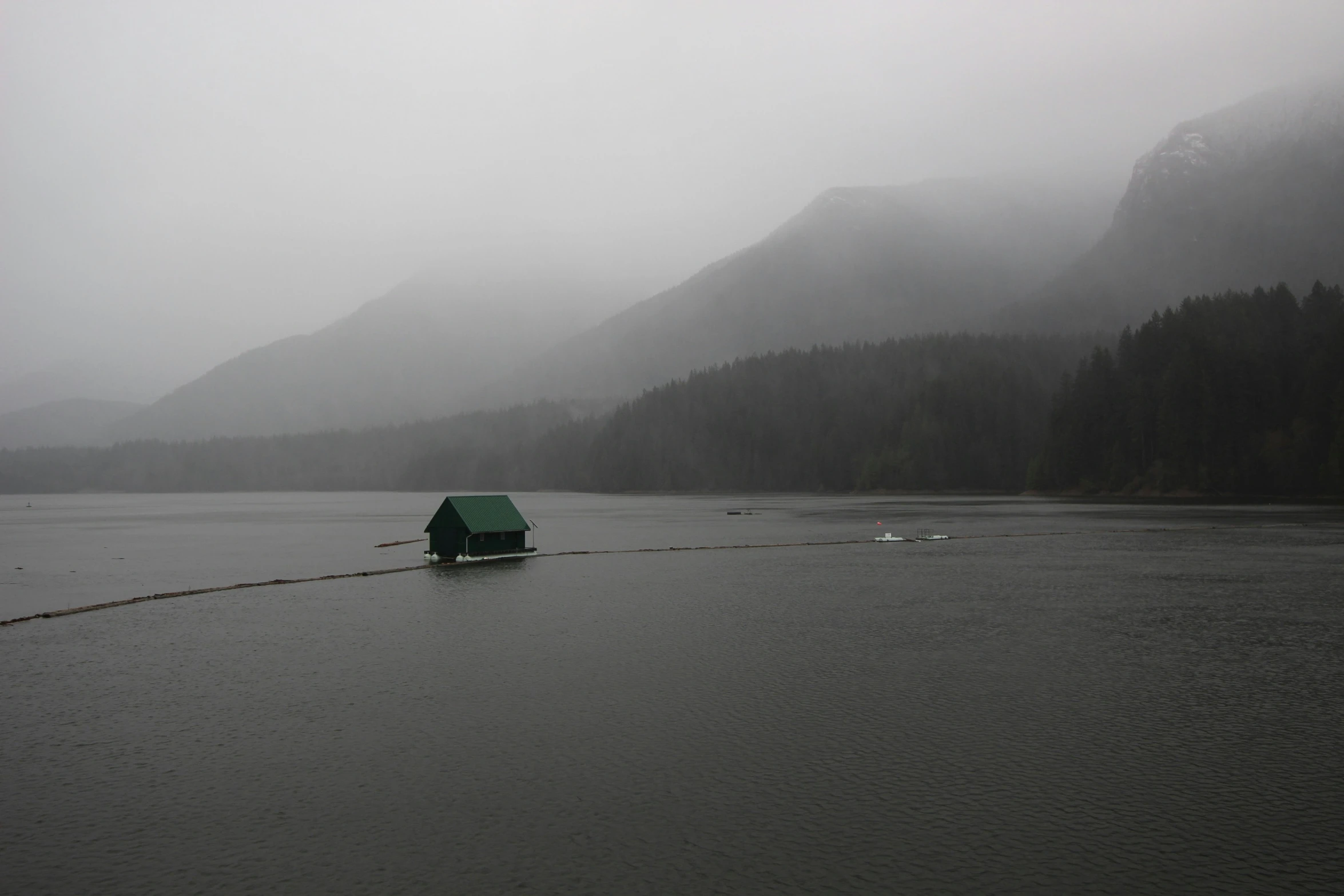 there is a hut on a rope at the end of the lake