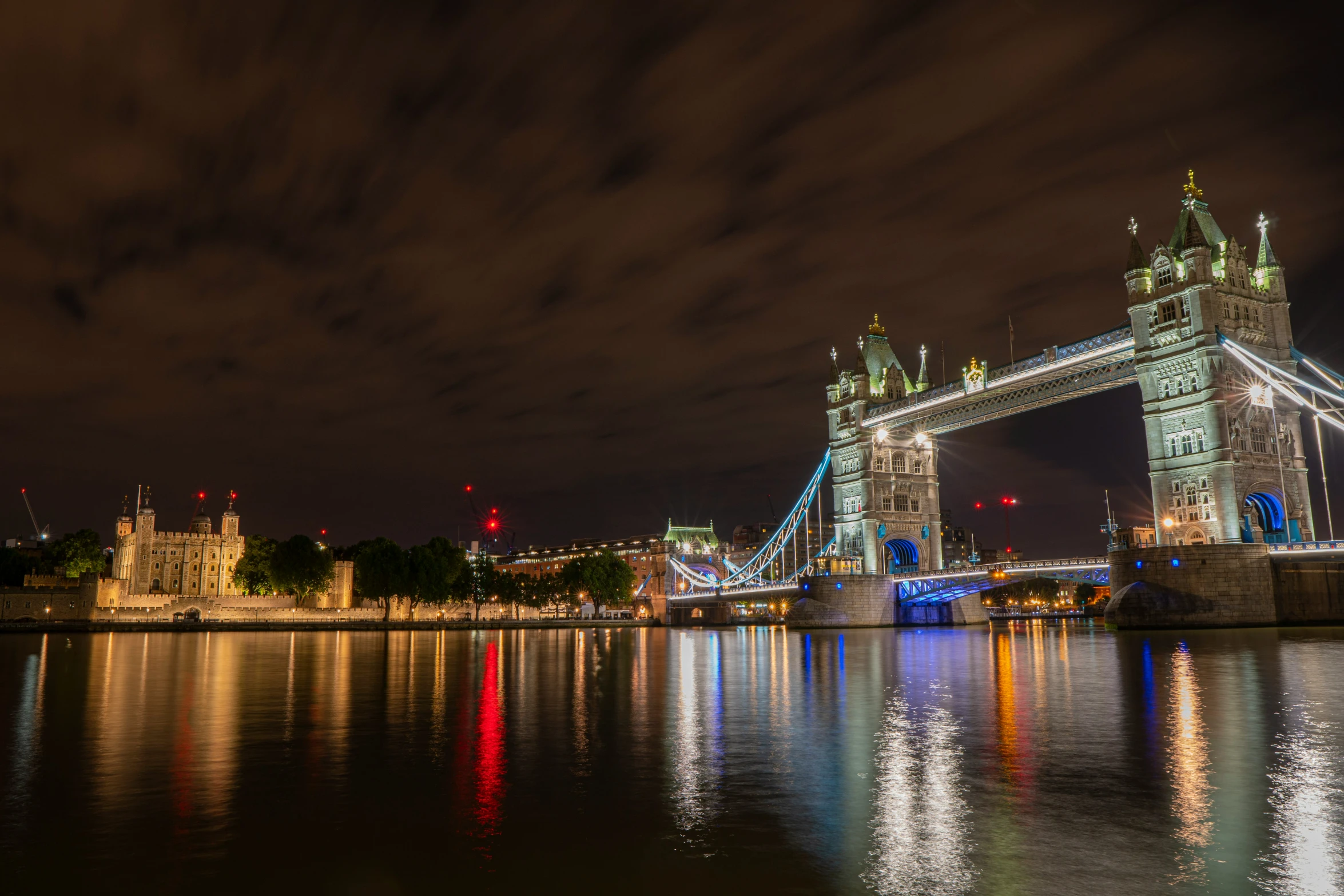 the lights of london's tower bridge are brightly lit at night