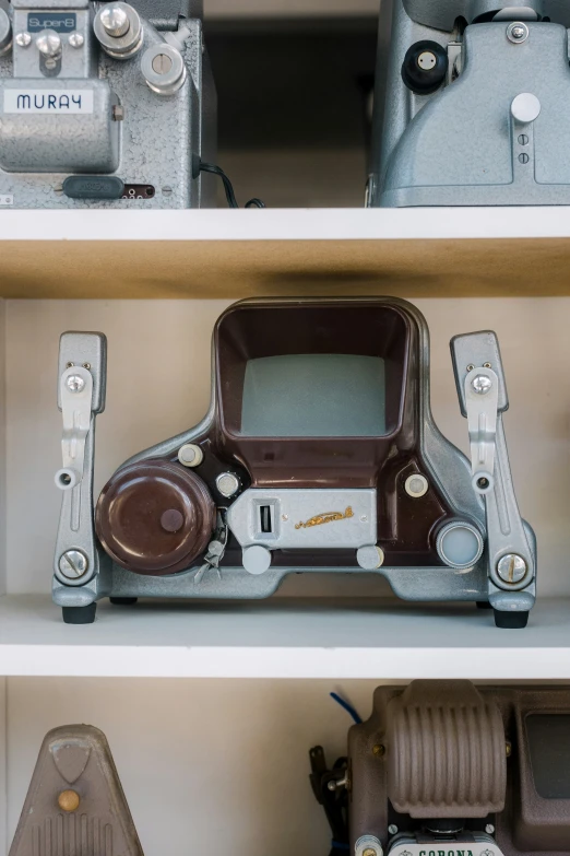 old cameras sit atop the shelves of a display case