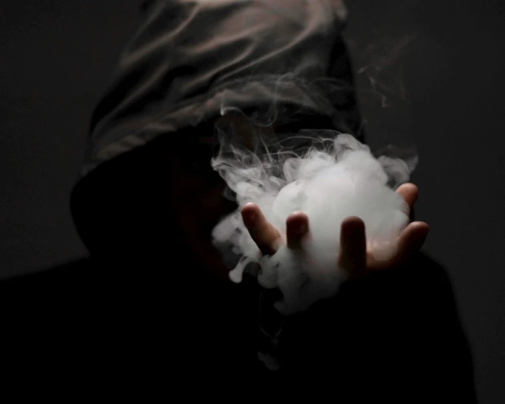 a person with an over head cap is holding a foggy object in their hand