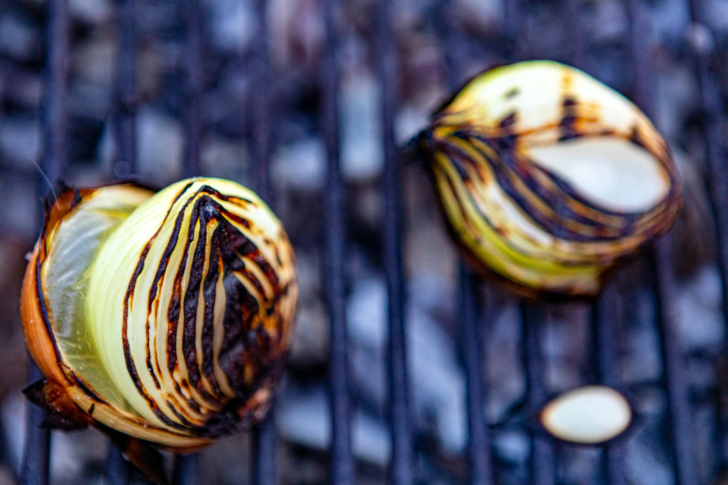 three peeled onions on top of grill grates