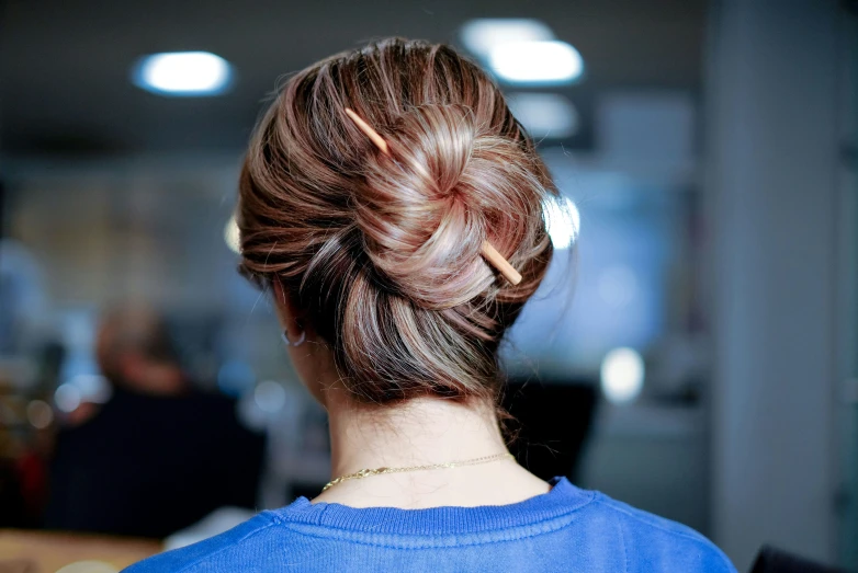 a woman with brown hair in a bun id