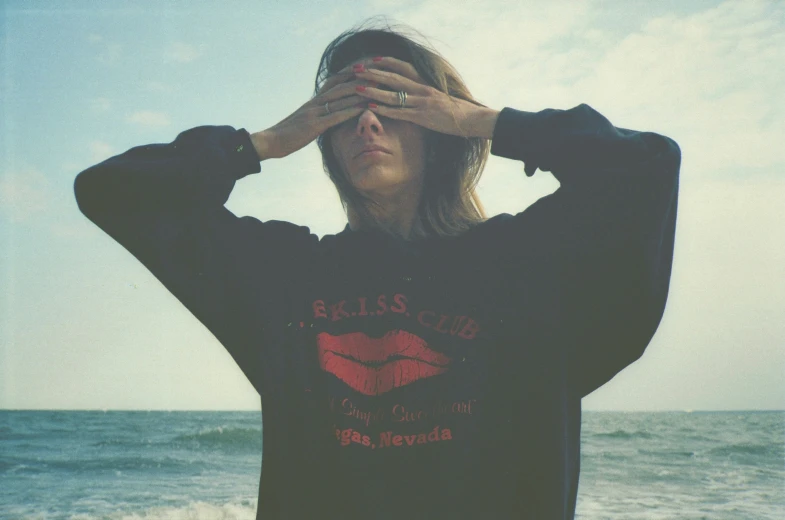 a woman wearing a black shirt standing on a beach