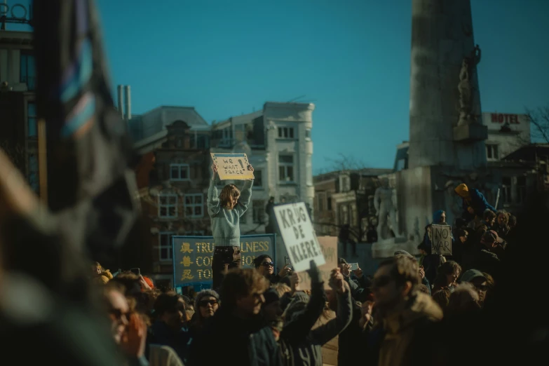 people stand in the street with signs and flags