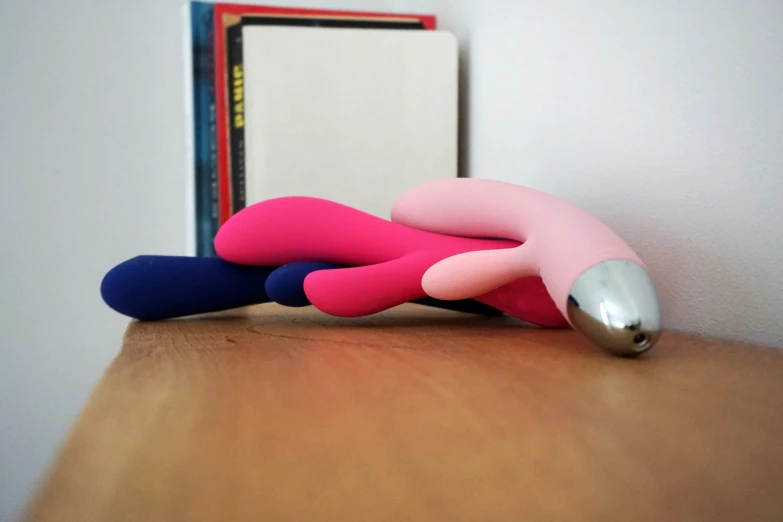 a little pink object lying on a desk next to a mirror