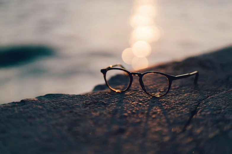 a pair of glasses sitting on a beach