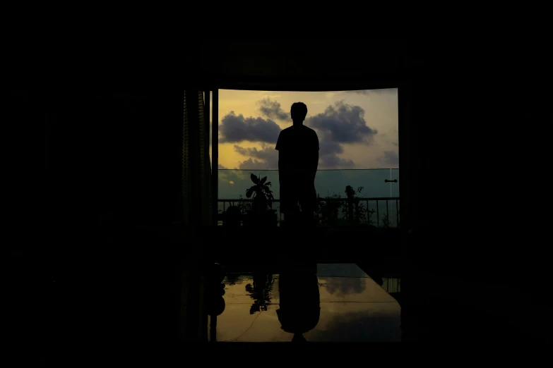 a silhouette image of the person standing outside of a door