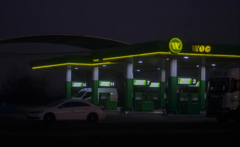 the gas station is lit up at night time