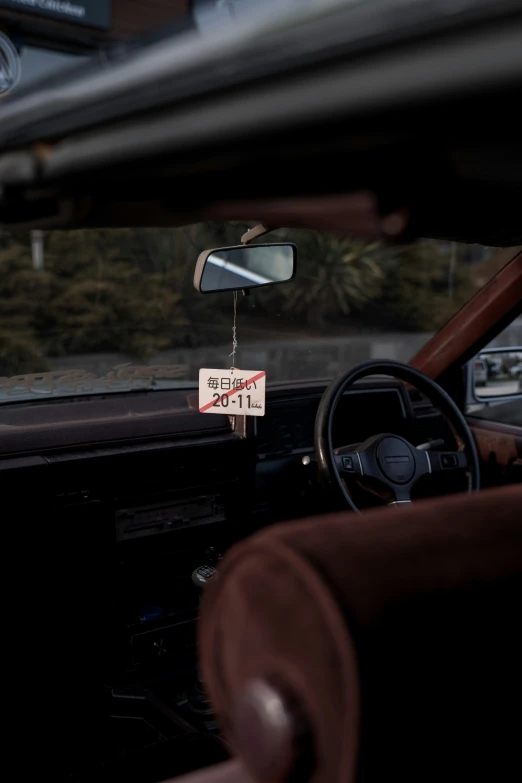 a person sitting in a car with a sign attached to it