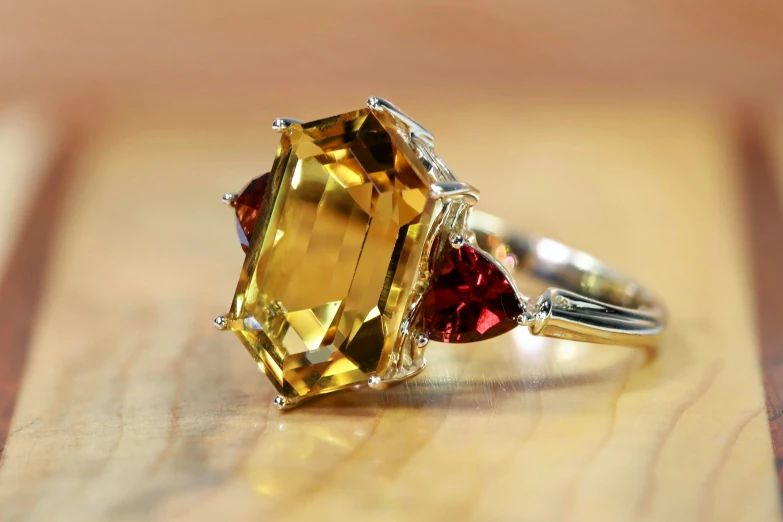 a ring with a large yellow sapphire and two red sapphires