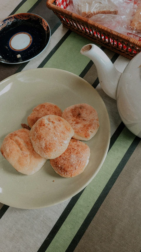 powdered pastry on a plate with an ornate basket of pastries in the background