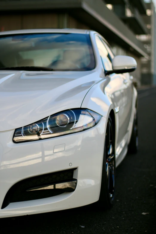 a white jaguar sitting in the middle of a parking lot