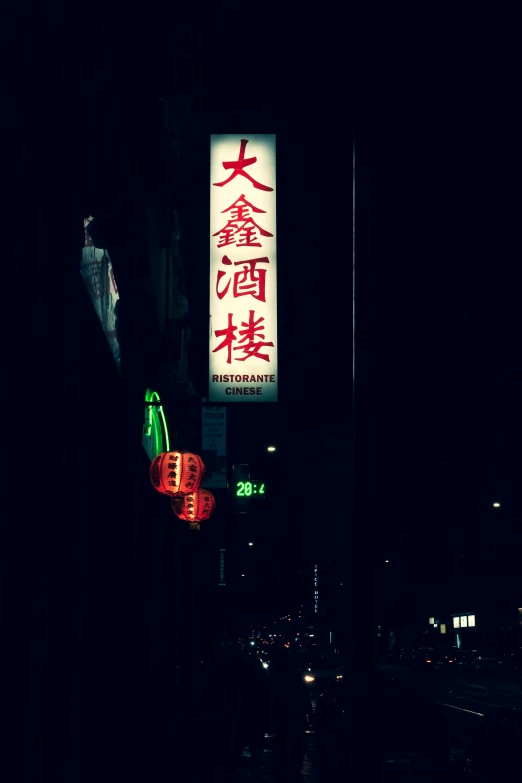 street sign with oriental characters on it at night