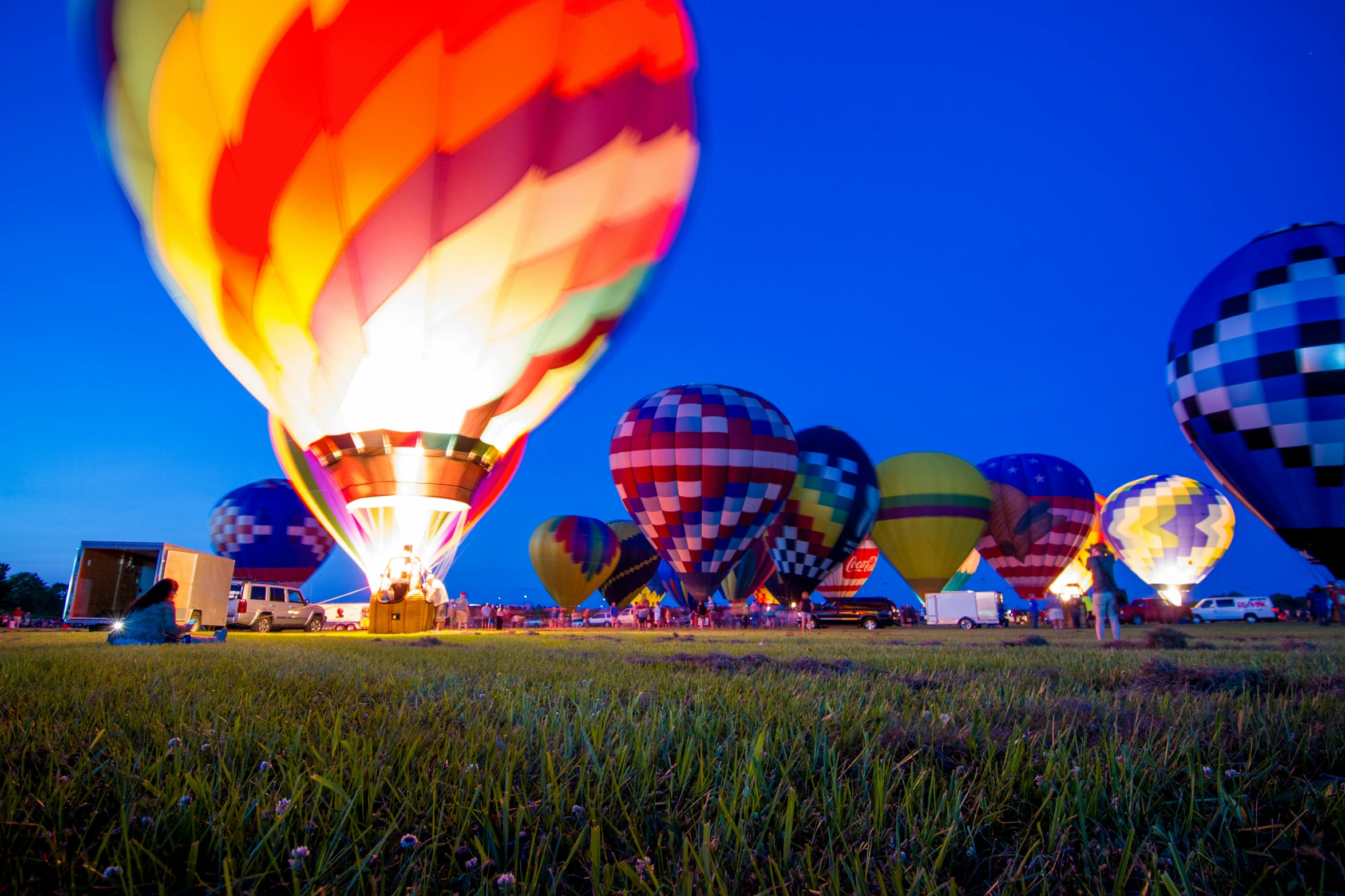 many  air balloons being flown over the grass