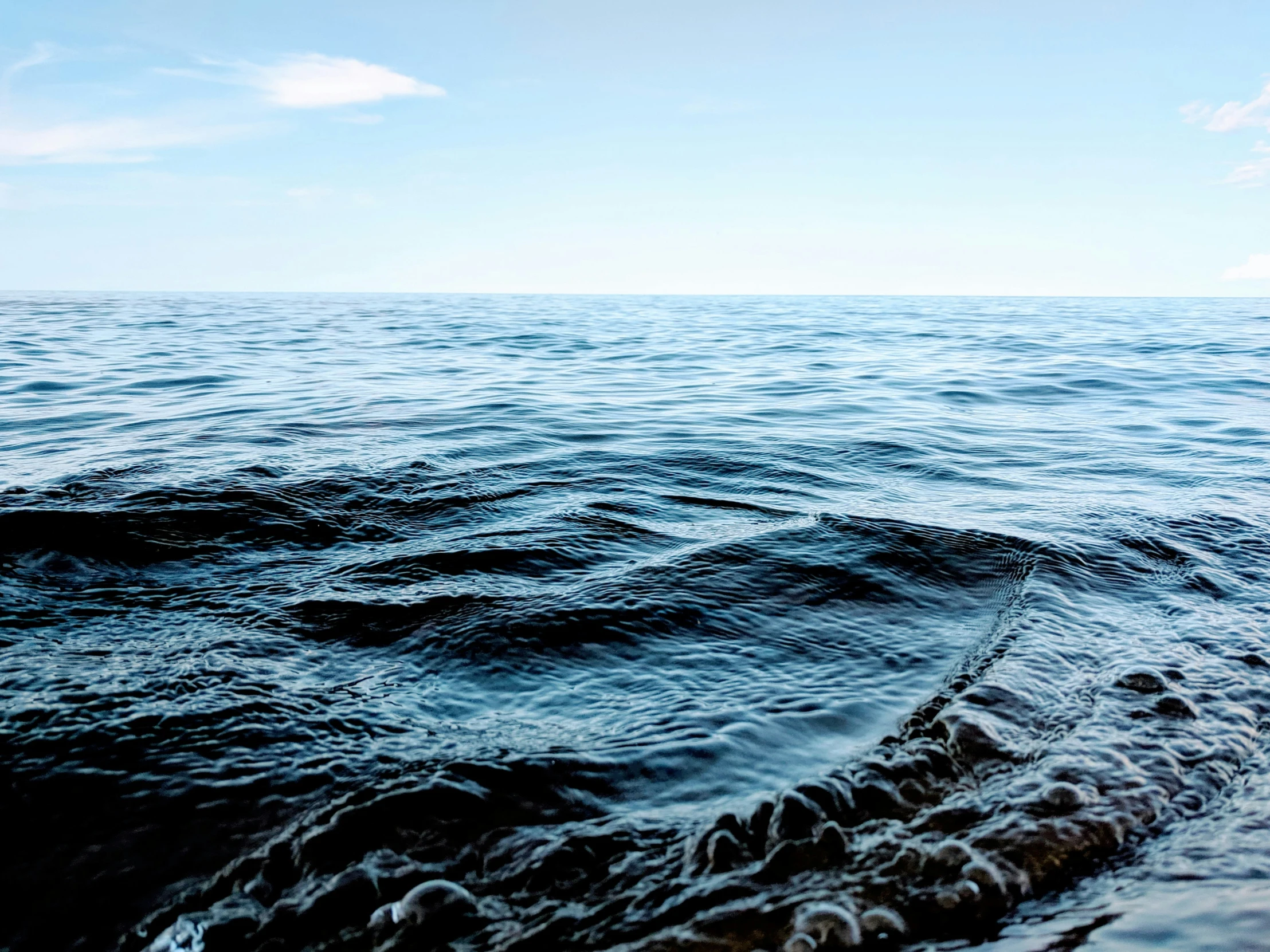 some waves coming to shore on a sunny day