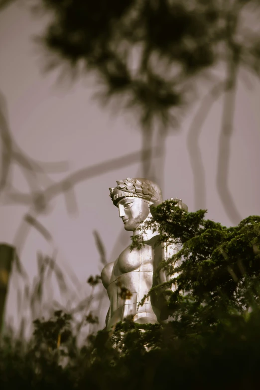 a statue that is standing behind trees