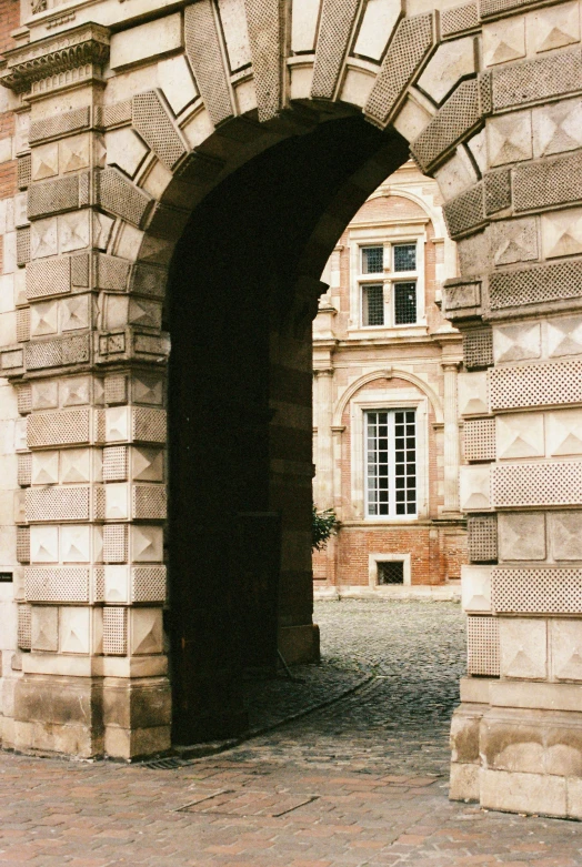 a very large arch between two building on a street