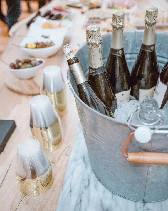 an outdoor table topped with bottles of wine