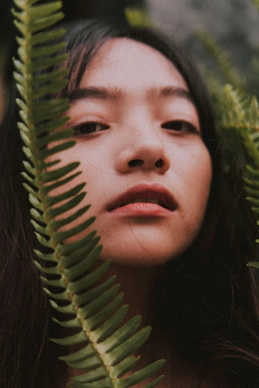 a close up of a person surrounded by leaves