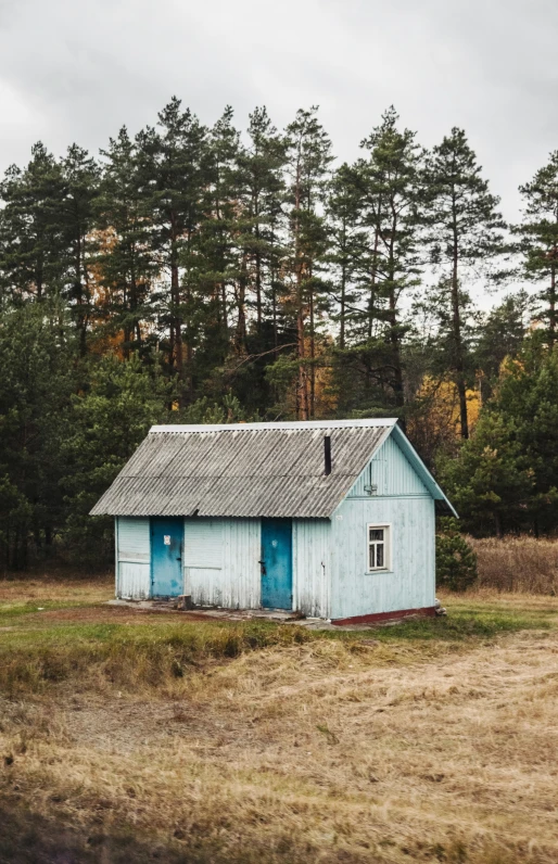 an old, rundown farm building is sitting out in a field