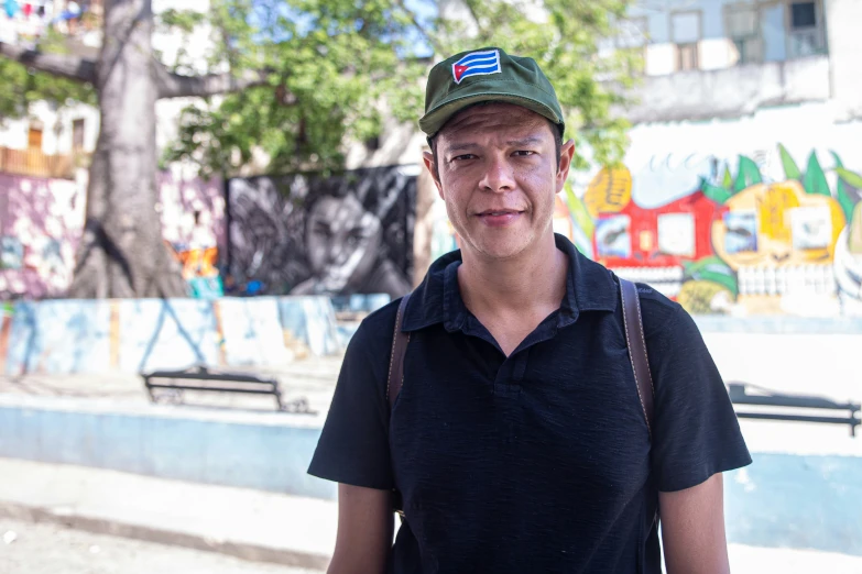 a man with suspenders and a hat posing for a picture