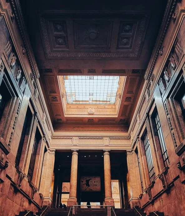 some tall ceilings and stairs in a large building