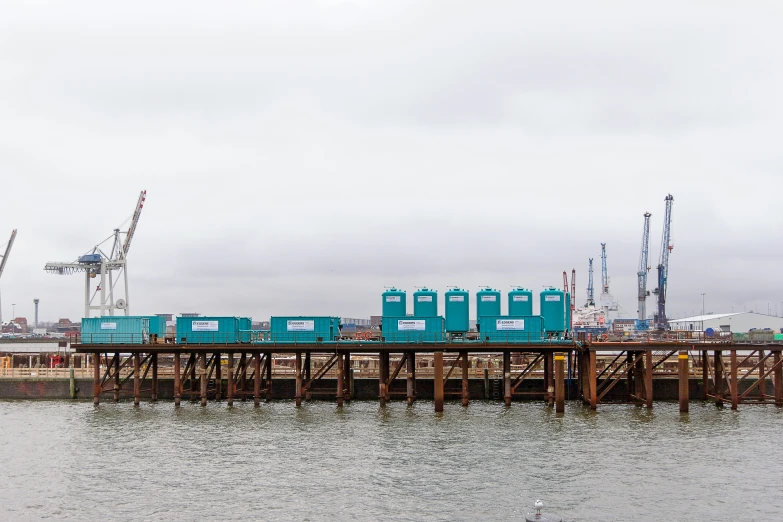 the small blue train is on the pier