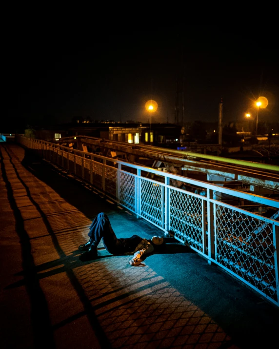 a man laying on the ground under the shade of a light