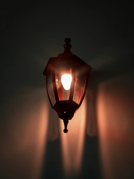 a single light fixture against a dark wall