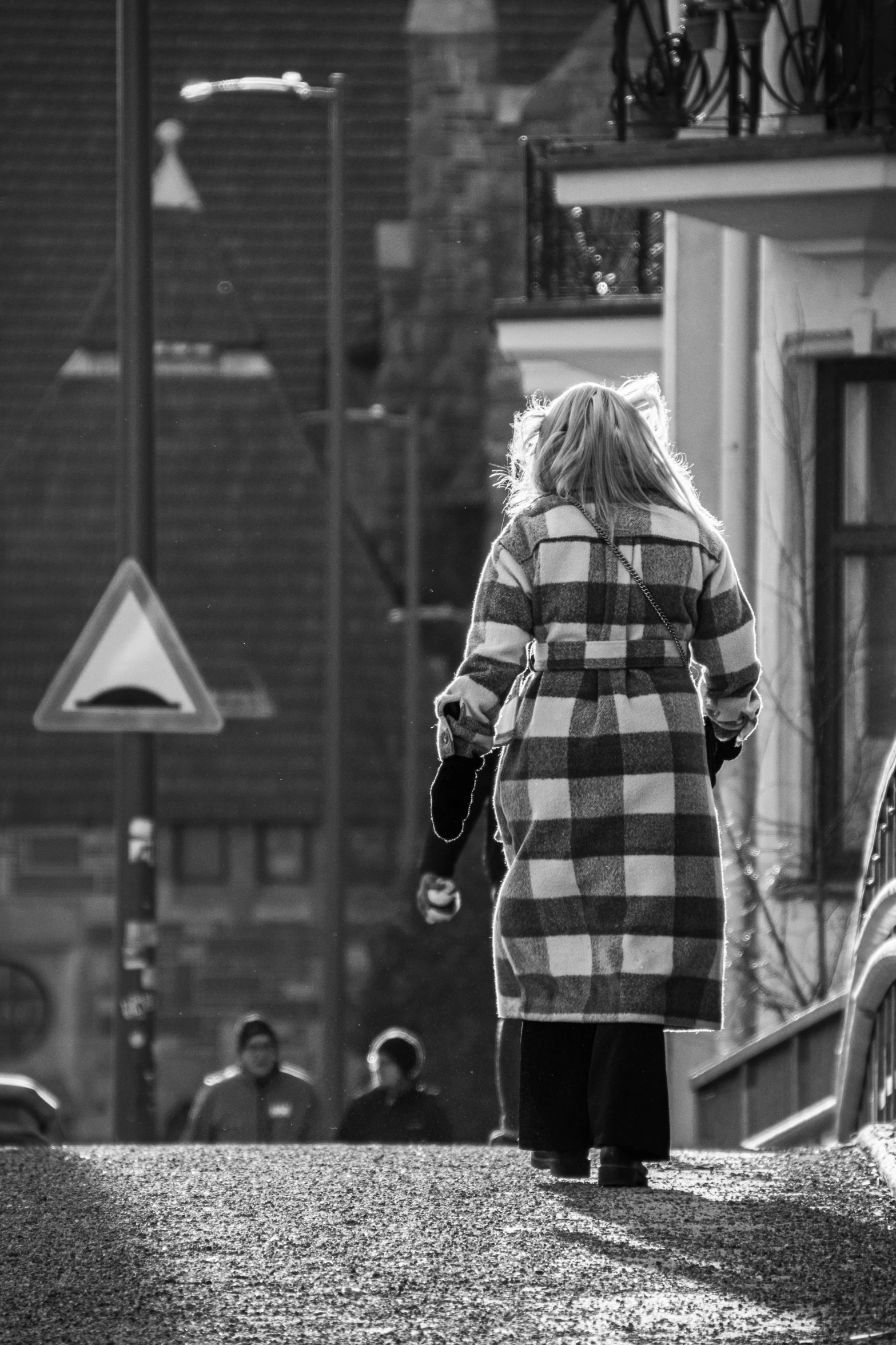 a woman walking down the street carrying a bag