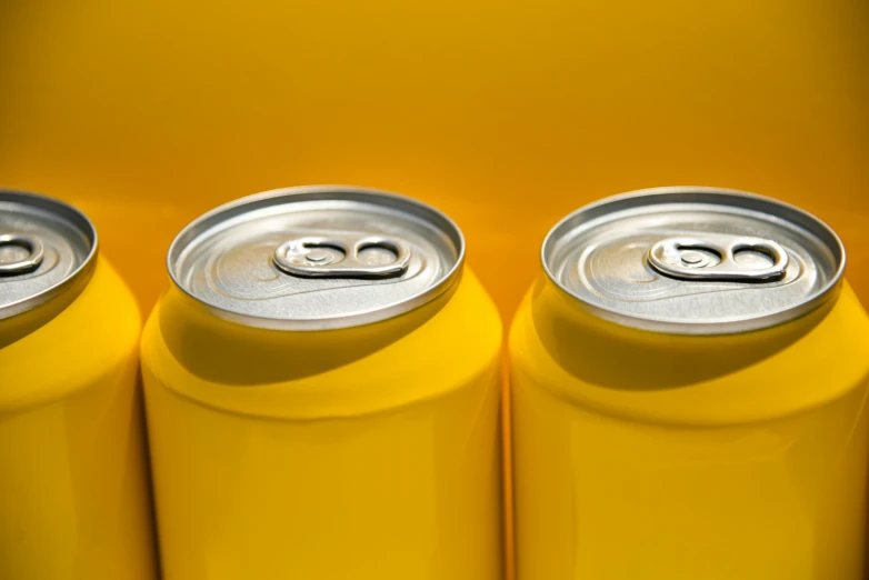 three can cans with silver lids are lined up in a row