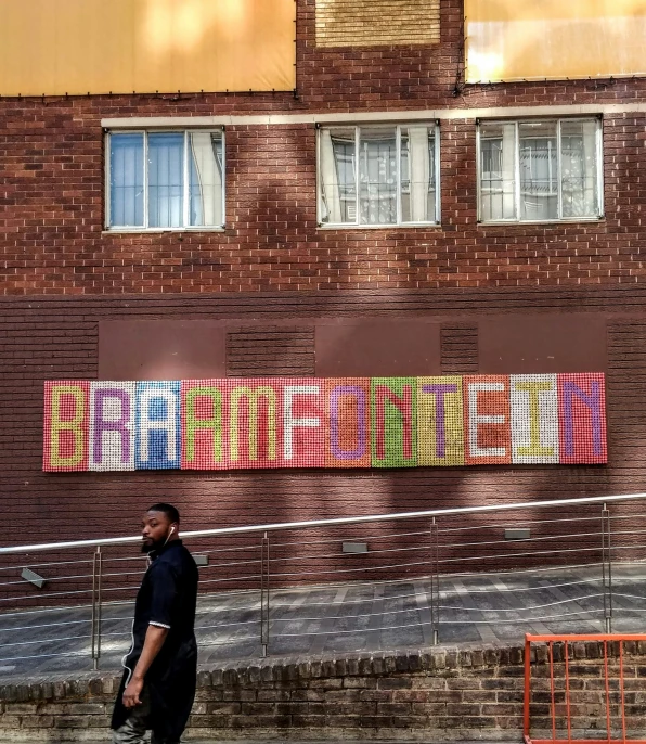 man walking past colorful building in city with windows