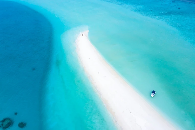 a boat floats in the water near an island in the middle of a blue ocean