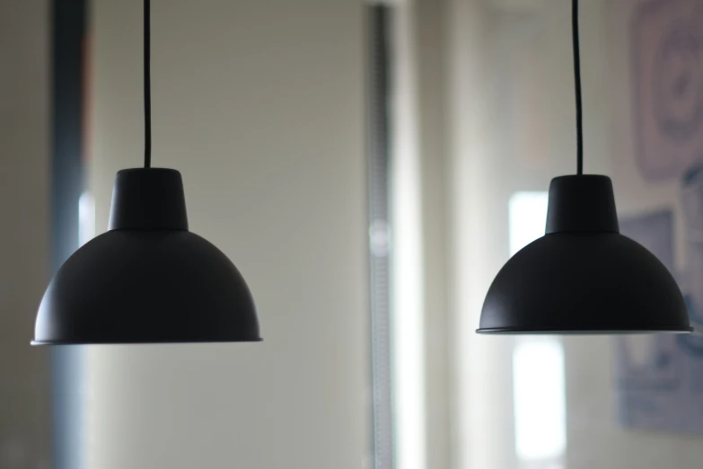 two lights sitting on a metal frame in front of mirrors