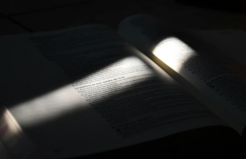 a book with light pouring in it and shadows on the page