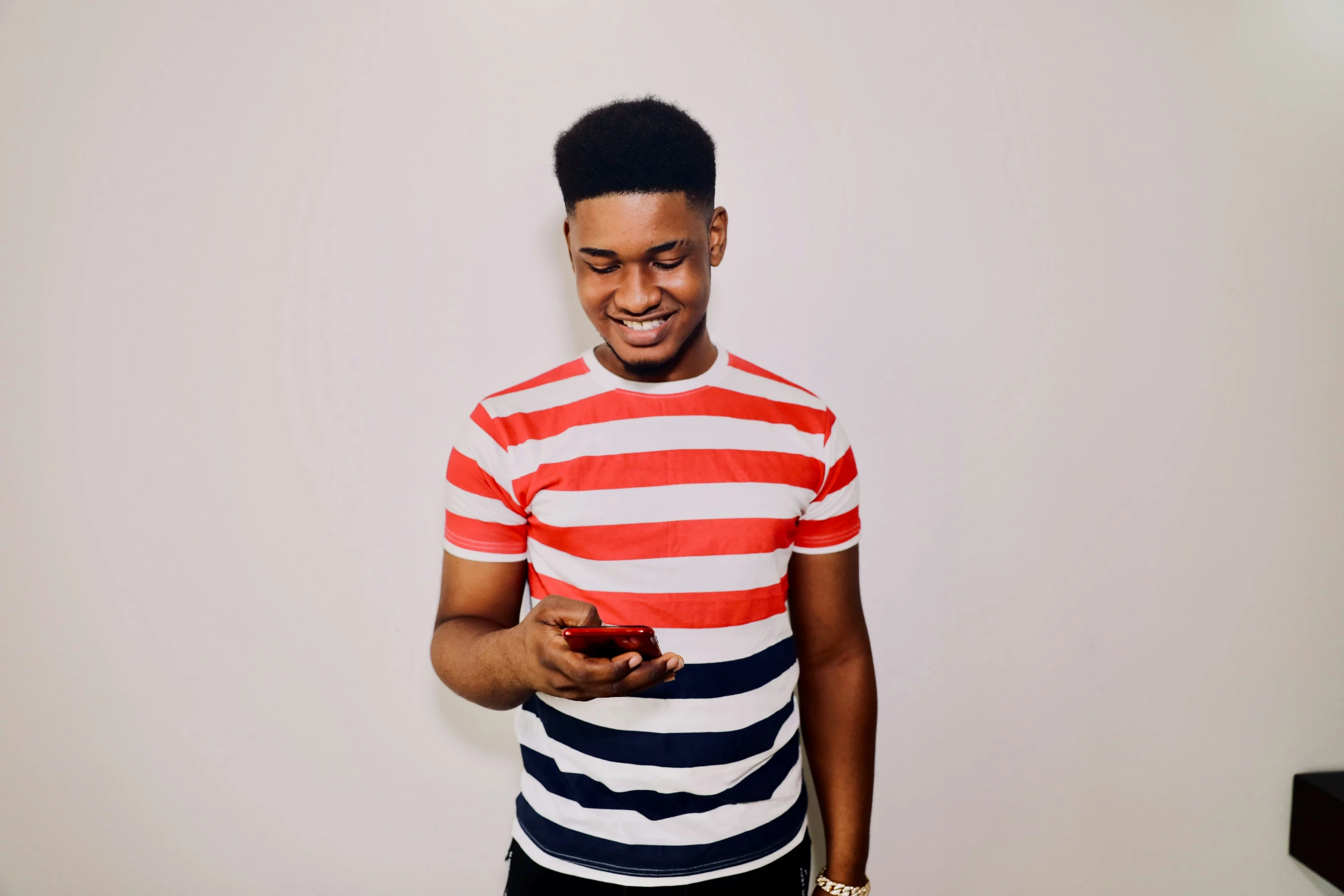 a man in striped shirt using cell phone