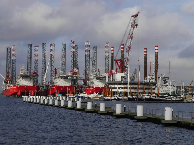 boats in harbor and some cranes in the background