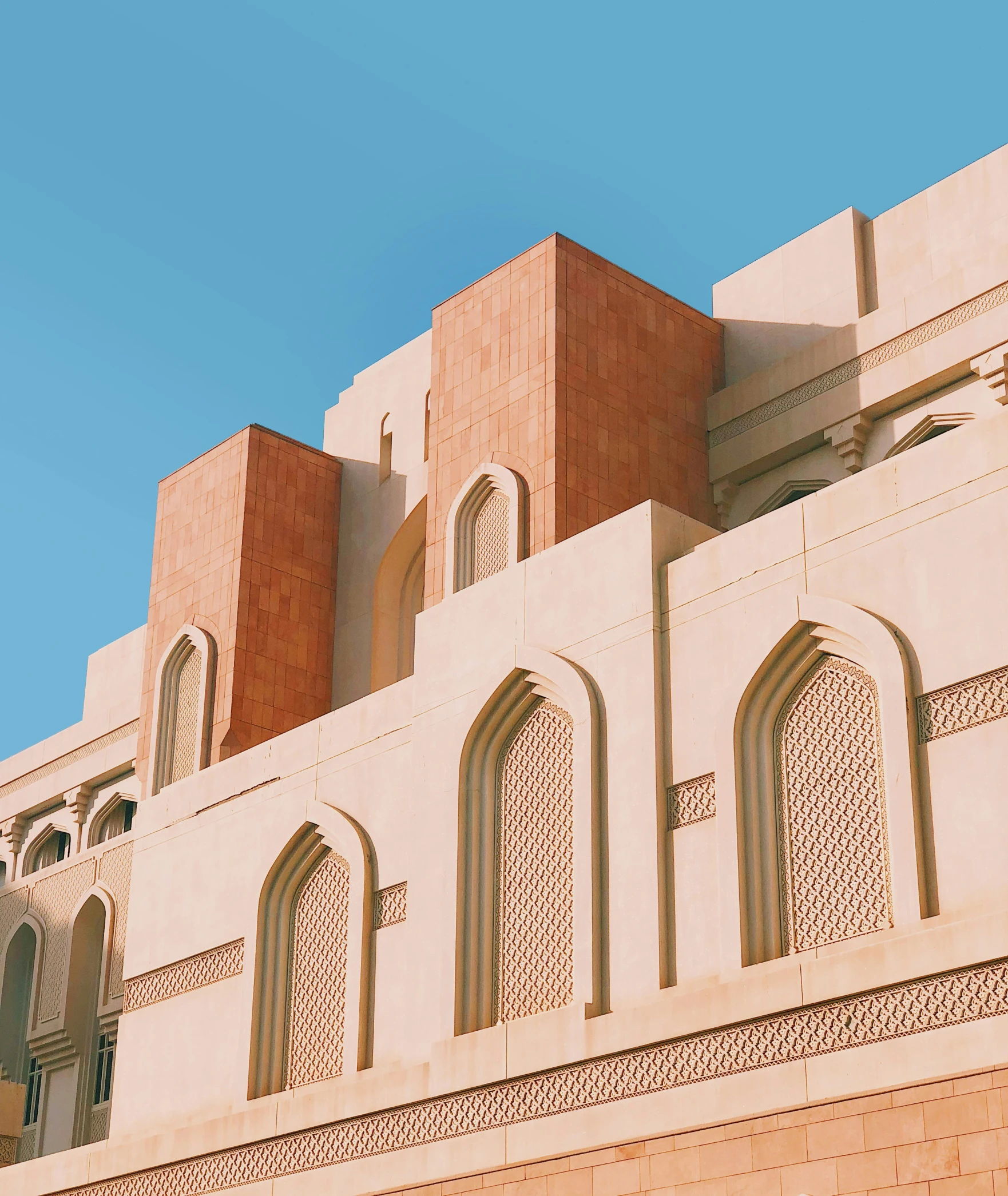 a building made out of clay and stone with a tall window above