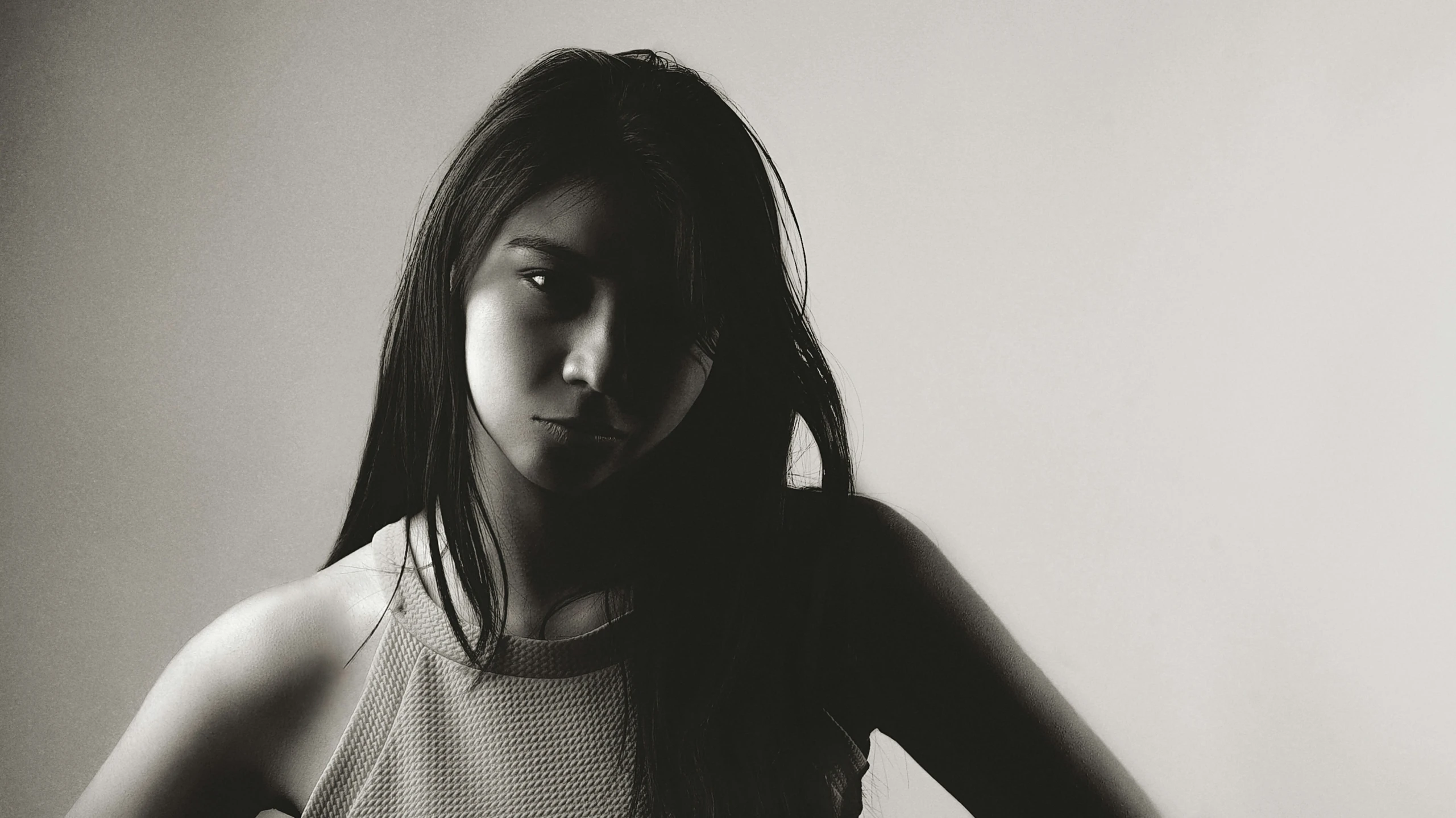 a black and white pograph of a young woman wearing a tank top