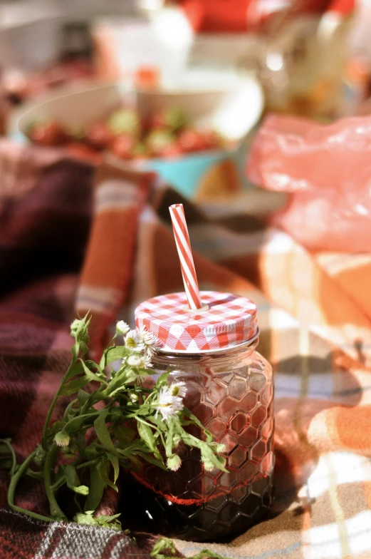 a jar that has a red and white stripe straw inside