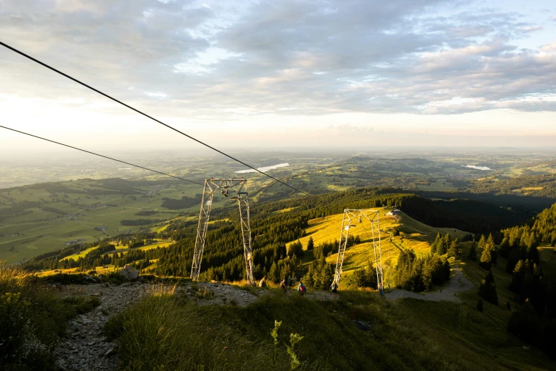 a mountain area with trees and mountains covered in grass